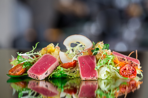 Delicious fresh tuna tataki salad with reflection