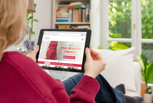 Mujer rubia mira digital tablet PC a la tienda en línea en internet photo