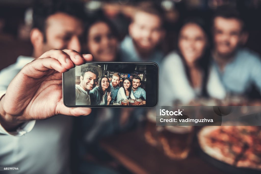 Friends makes selfie Selfie time! Handsome friends making selfie and smiling while resting at pub. Friendship Stock Photo