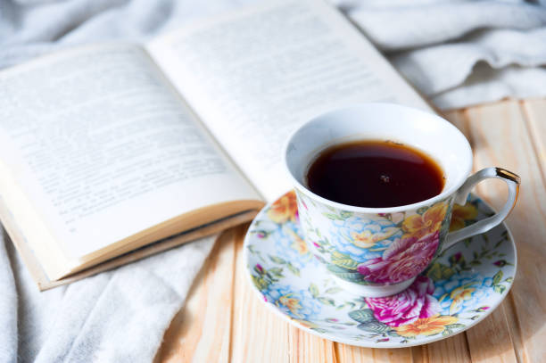 istock Cozy home still life: cup of hot coffee or tea and opened book with warm plaid 685192264