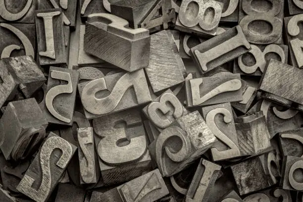 numbers abstract - background of random letterpress wood type printing blocks, top view, black and white platinum toned image