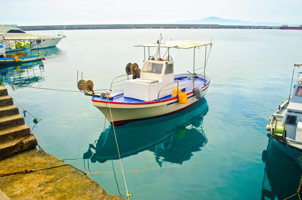 the reflection of a fishing boat on sea Greece