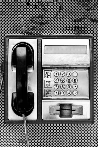Public phone. Telephone booth close up. Black and white.