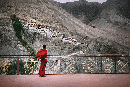 Diskit, Leh district, India - August 21, 2016:Buddhist Monk in red robe looks on Diskit Monastery, Indian Himalaya, Nubra Valley on AUGUST 21, 2016