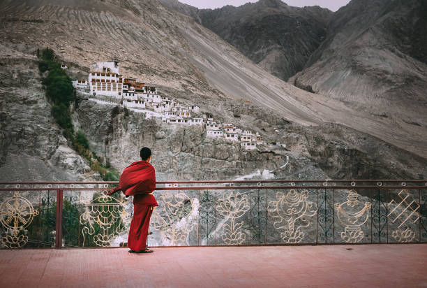 Buddhist Monk in red robe looks on Diskit Monastery, Indian Himalaya, Nubra Valley Diskit, Leh district, India - August 21, 2016:Buddhist Monk in red robe looks on Diskit Monastery, Indian Himalaya, Nubra Valley on AUGUST 21, 2016 ladakh region stock pictures, royalty-free photos & images