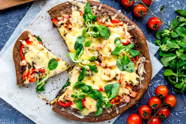 ingredients and vegetarian pizza on blue stone table background top view
