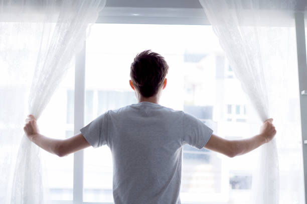istock man and hope concept - man opening window curtains business concept. 685262760