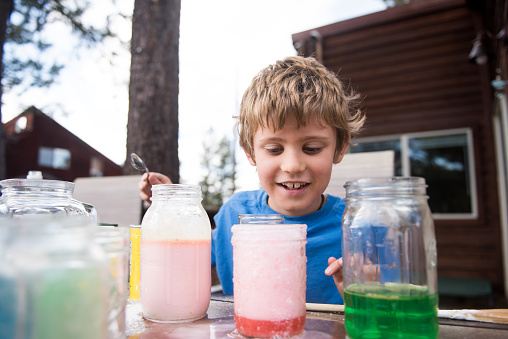 child experiments with chemicals and liquid outside