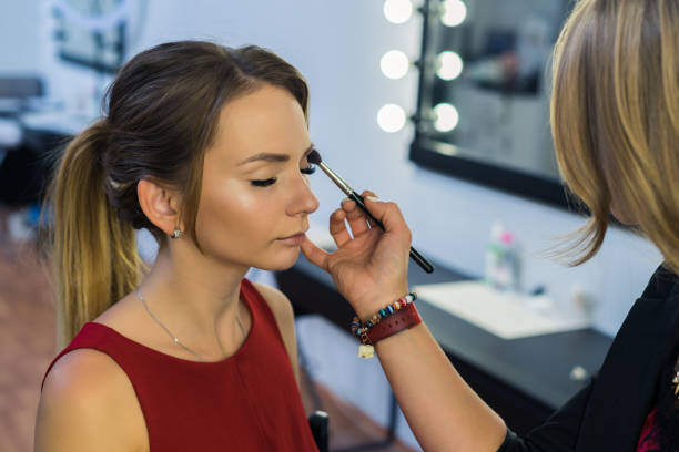istock Make-up artist doing makeup to beautiful young girl 685386338