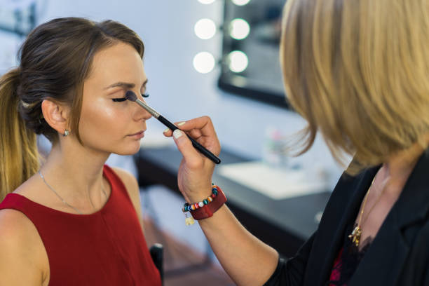 istock Make-up artist doing makeup to beautiful young girl 685386362