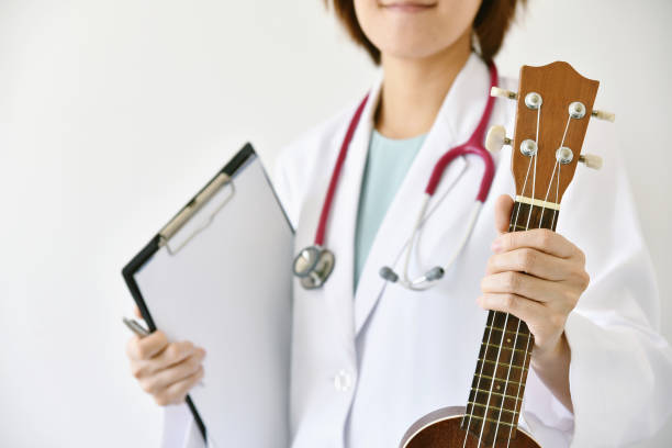 arzt-hand mit ukulele (musikinstrument), musik-therapie-konzept. - stethoscope medical supplies medical instrument medical equipment stock-fotos und bilder