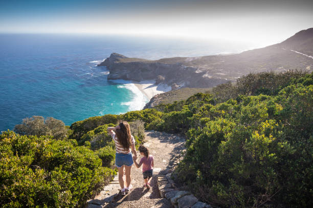 Mother and daugher at Cape Point enjoying the view Asian mother and daughter are walking down the stone footpath at Cape point - located south of Cape Town, South Africa. Shot in April 2017, during Fall. cape peninsula photos stock pictures, royalty-free photos & images