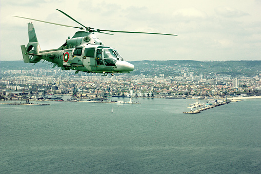 Military navy helicopter flying over coastline of a big city closeup -Varna, Bulgaria
