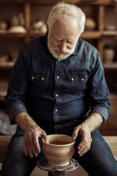 istock Senior potter making pottery on a wheel at workshop 685460822