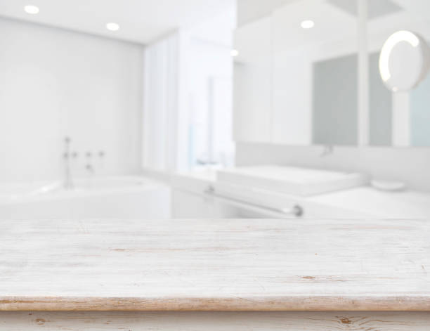 Background of blurred bathroom interior with wooden table in front Background of blurred bathroom interior with wooden table in front spa cleaning stock pictures, royalty-free photos & images