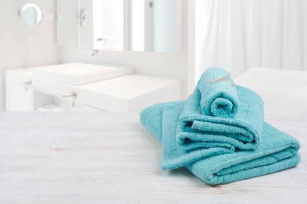 istock Turquoise spa towels on wooden surface over blurred bathroom background 685470858