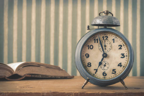 istock An old alarm clock and an open book 685478670