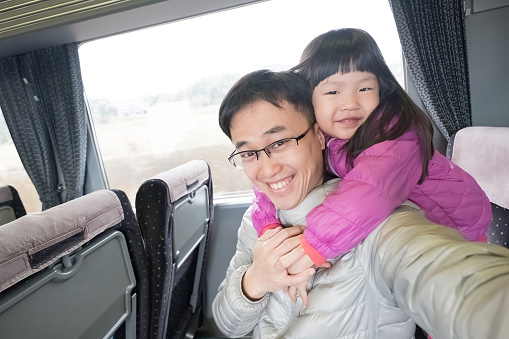 father and daughter selfie happily in the bus