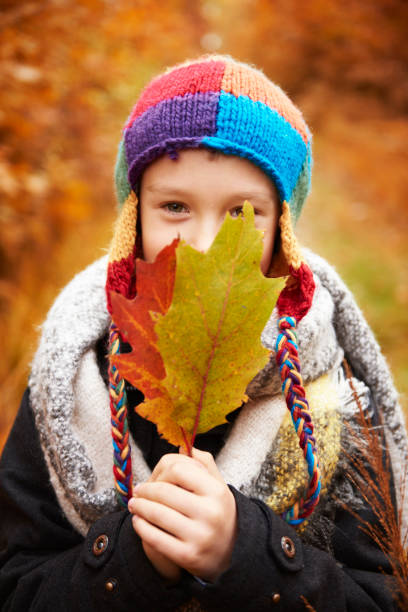 istock Boy covering face with autumn leaf 685483982