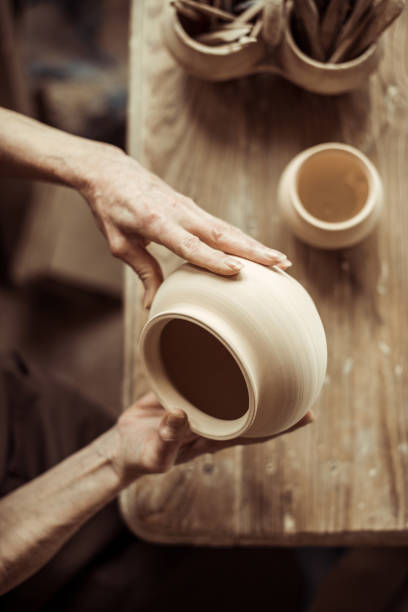 istock Close up of female hands examining ceramic bowl at workshop 685488830