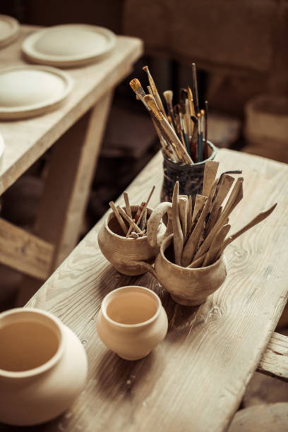 istock Close up of paint brushes with pottery tools in bowls on table 685492358