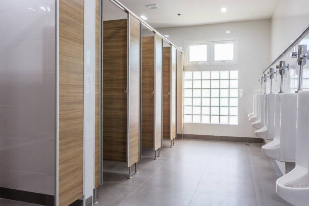 urinarios blancos en la sala de aseo público de hombres limpios vacíos con gran ventana - bathroom contemporary office sparse fotografías e imágenes de stock