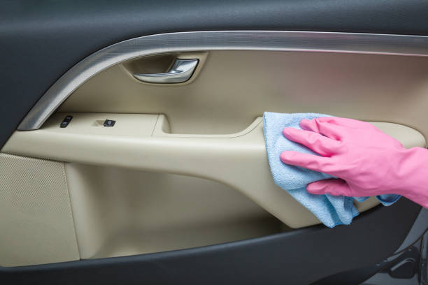 istock Hand in rubber protective glove with rag cleaning a car interior's door. Early spring cleaning or regular clean up. 685499310
