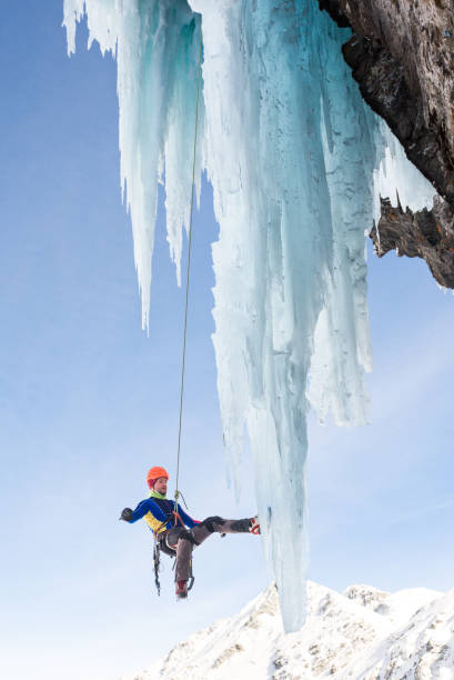 istock Male ice climber hanging on massive icicle 685499852