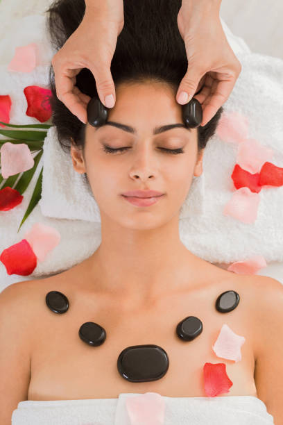 kosmetyczka zrobić masaż z kamienia spa dla kobiety w centrum odnowy biologicznej - massage table massaging sport spa treatment zdjęcia i obrazy z banku zdjęć