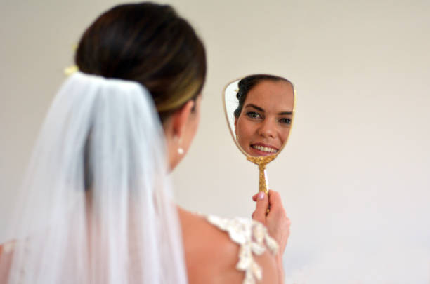 Young bride looks at herself in the mirror on her Wedding Day. Woman,self esteem, self image, wedding and marriage concept. copy space