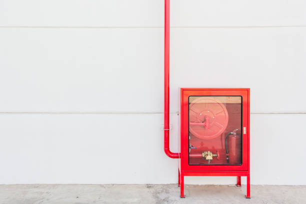 istock Red fire hose cabinet and extinguisher on white wall 685503430