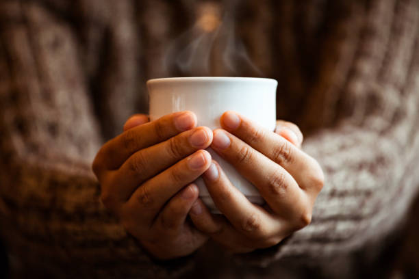mano donna che tiene la tazza di caffè o tè nel caffè nella giornata piovosa - camera retro revival old fashioned holding foto e immagini stock