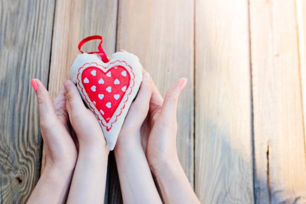 enfant et sa mère tenant coeur dans les mains - heart shape human hand charity and relief work giving photos et images de collection