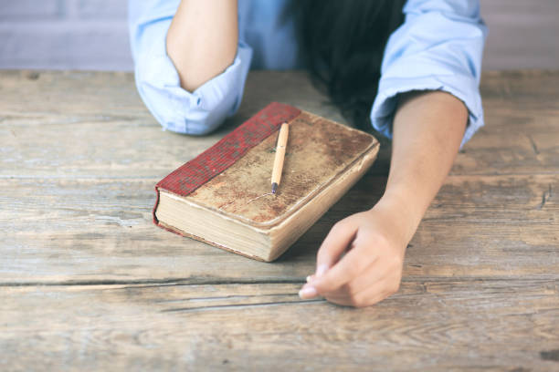 istock woman hand on book 685549104