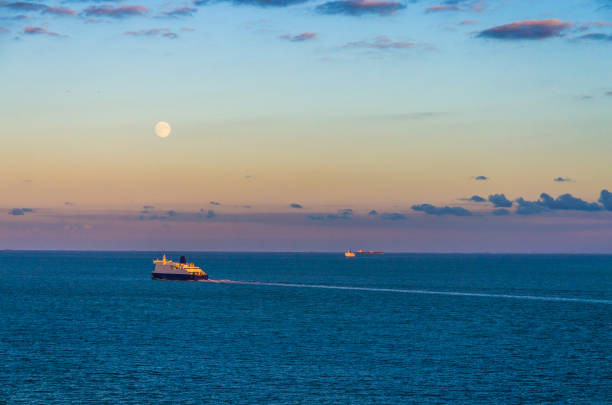 Distant ships crossing the English Channel at twilight Photograph taken from Dover of the busy strait between the ports of Dover (England) and Calais (France) ferry dover england calais france uk stock pictures, royalty-free photos & images