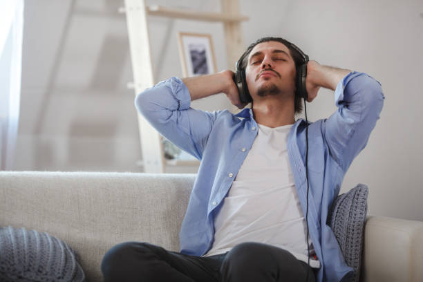 istock Handsome guy sitting on sofa with headphones 685569454