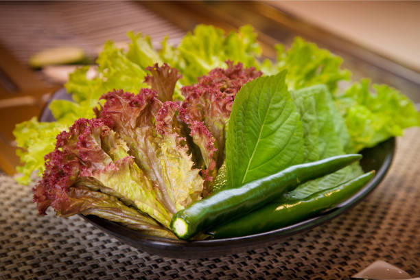 istock Fresh green chili pepper with lettuce on black bowl 685595984