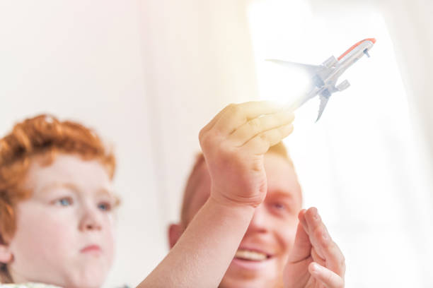 istock smiling father and son playing with toy plane at home 685621814