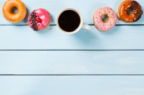 istock Cup with coffee and donuts on blue wooden table. Top view and free space for your text 685631100