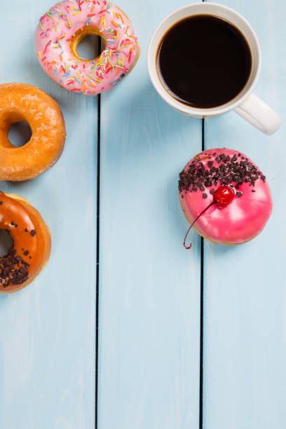 istock Cup with coffee and donuts on blue wooden table. Top view and free space for your text 685631102