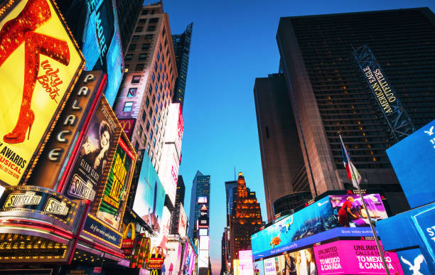 Times Square advertising illuminated at dusk Billboards and screen images adorn the buildings around Times Square in Manhattan, New York City. theatre district stock pictures, royalty-free photos & images