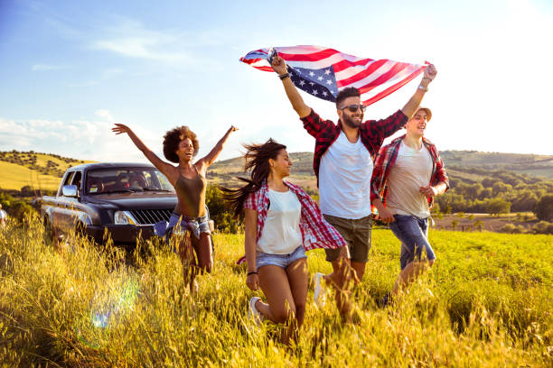 istock Friends celebrating together holding a US flag on field 685638870