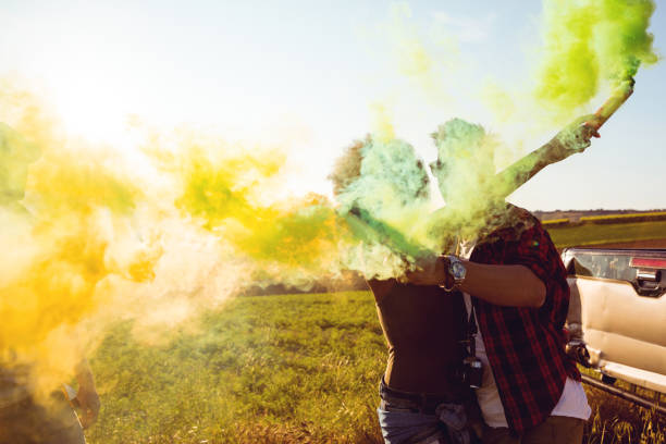 istock Friends holding smoke bombs having fun in a field 685641112