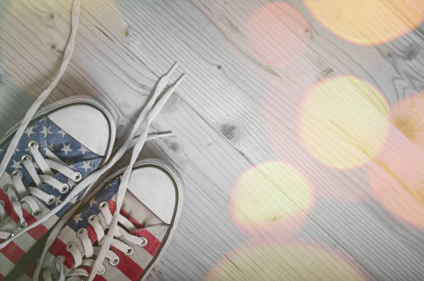 Sneakers with USA flag on wooden background Sneakers with USA flag on wooden background with bokeh lights usa flag shoes stock pictures, royalty-free photos & images