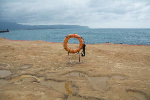 Life ring on beach and cloudy sky stock photo