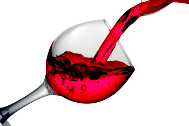istock Red dry wine pours into a wineglass on a white background 685655862