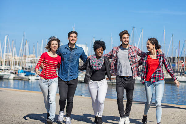 istock Young women and men at harbor on sunny day 685668190
