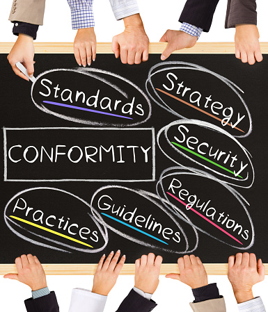 Photo of business hands holding blackboard and writing CONFORMITY concept