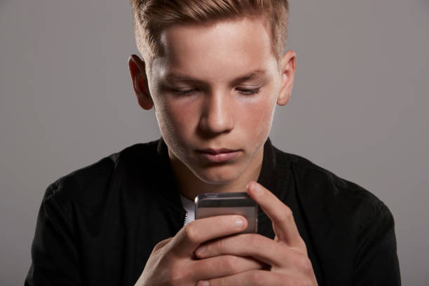 istock White teenage boy using mobile phone, head and shoulders 685675860