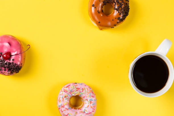 istock Cup with coffee and donuts on yellow background. Top view and free space for your text 685680242
